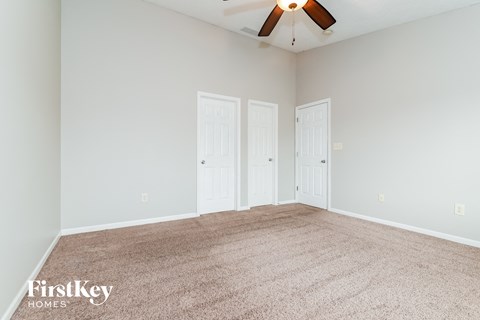 a bedroom with two doors and a ceiling fan