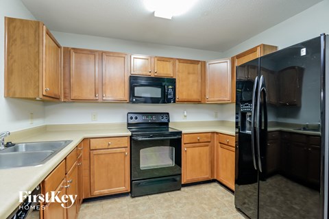 a kitchen with black appliances and wooden cabinets