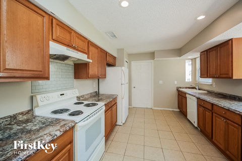 a kitchen with white appliances and wooden cabinets