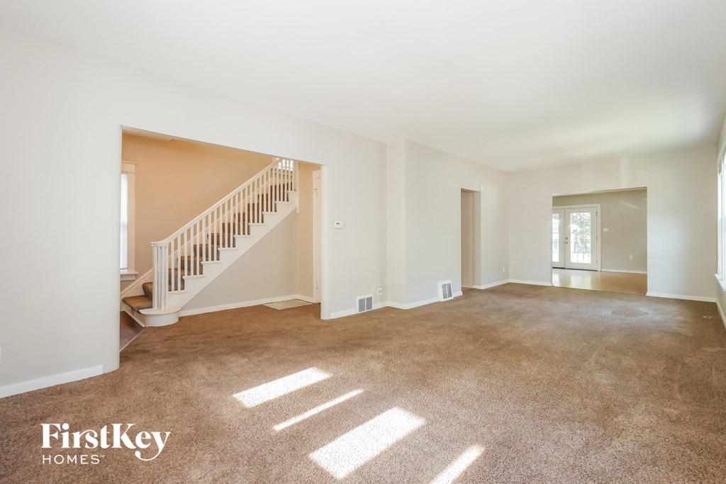 A spacious room with a staircase leading to the second floor.