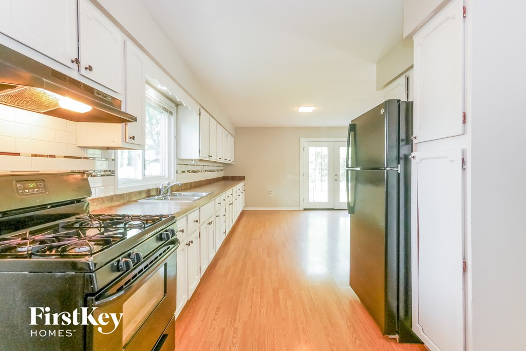 A kitchen with a stove top oven and a refrigerator.