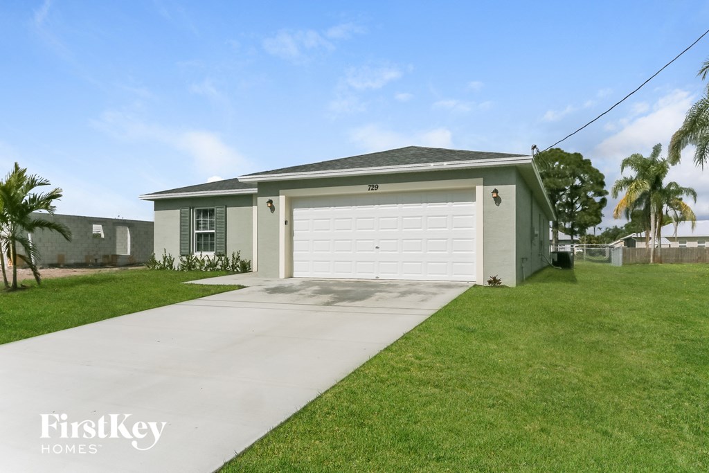 a small green house with a white garage door