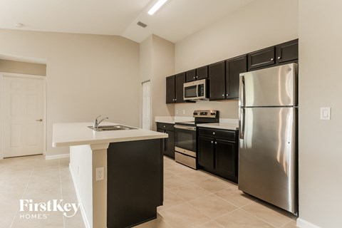 a kitchen with stainless steel appliances and black cabinets
