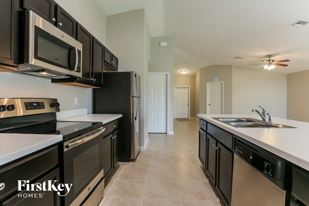 a large kitchen with stainless steel appliances and black and white counters