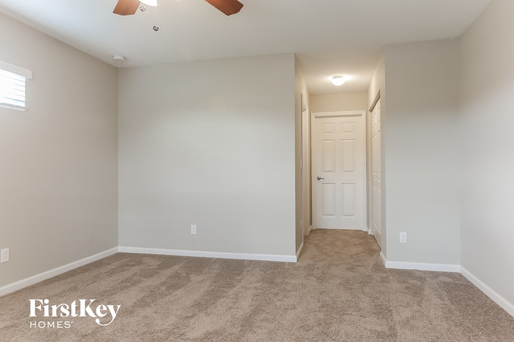 a room with a carpeted hallway and a door to a closet