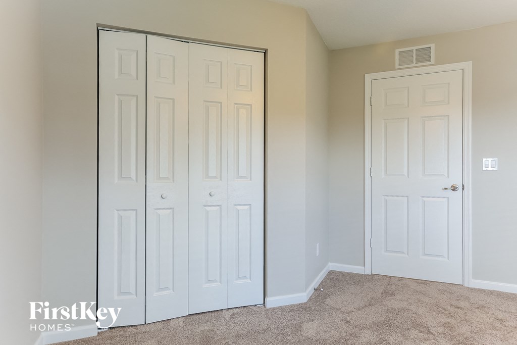 a closet with two white doors and a carpeted floor