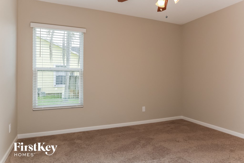 a bedroom with a carpeted floor and a window