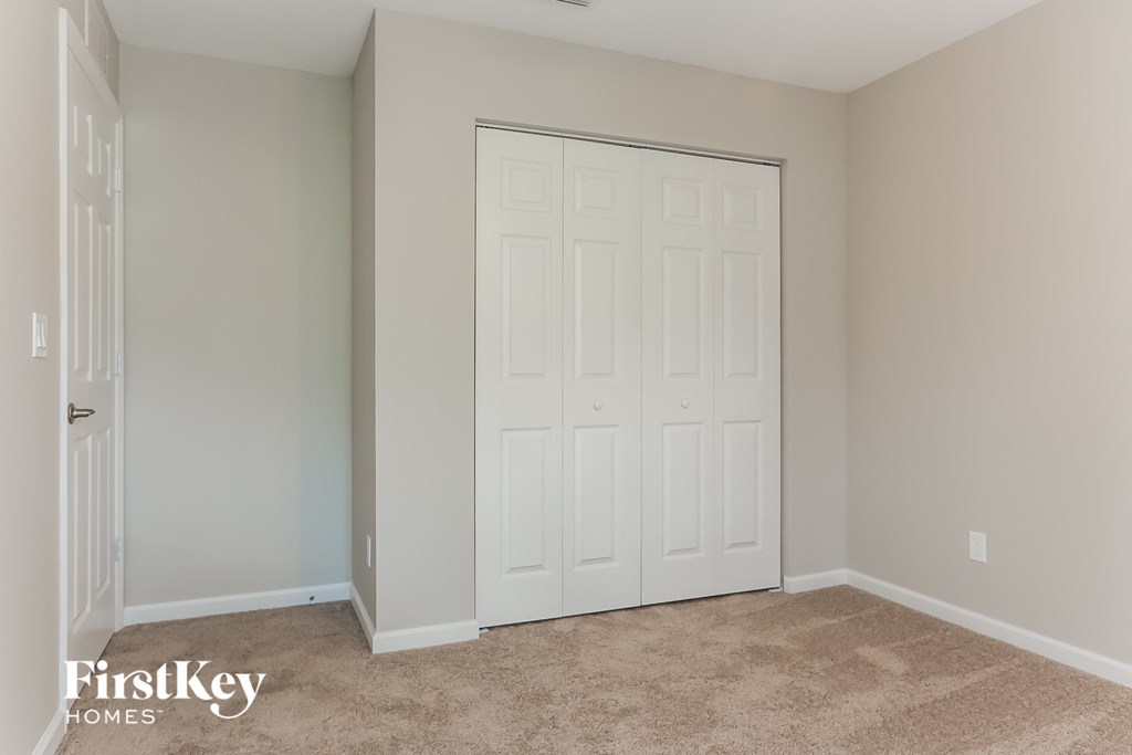 a bedroom with two closets and a carpeted floor