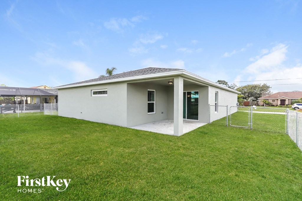 a small white house with a yard and a fence