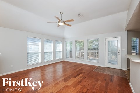 a living room with wood floors and a ceiling fan
