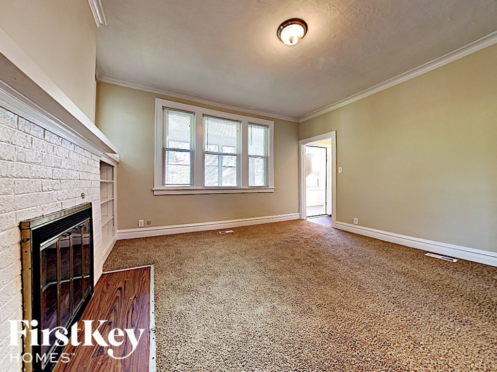 an empty living room with a fireplace and a window