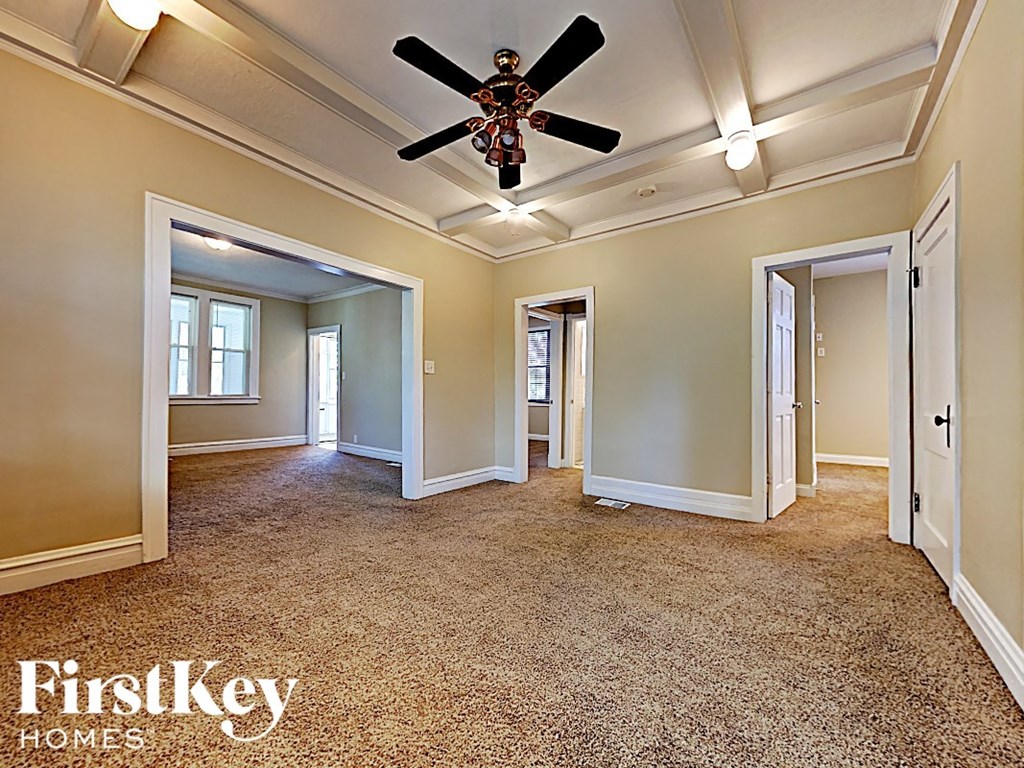 an empty living room with a ceiling fan