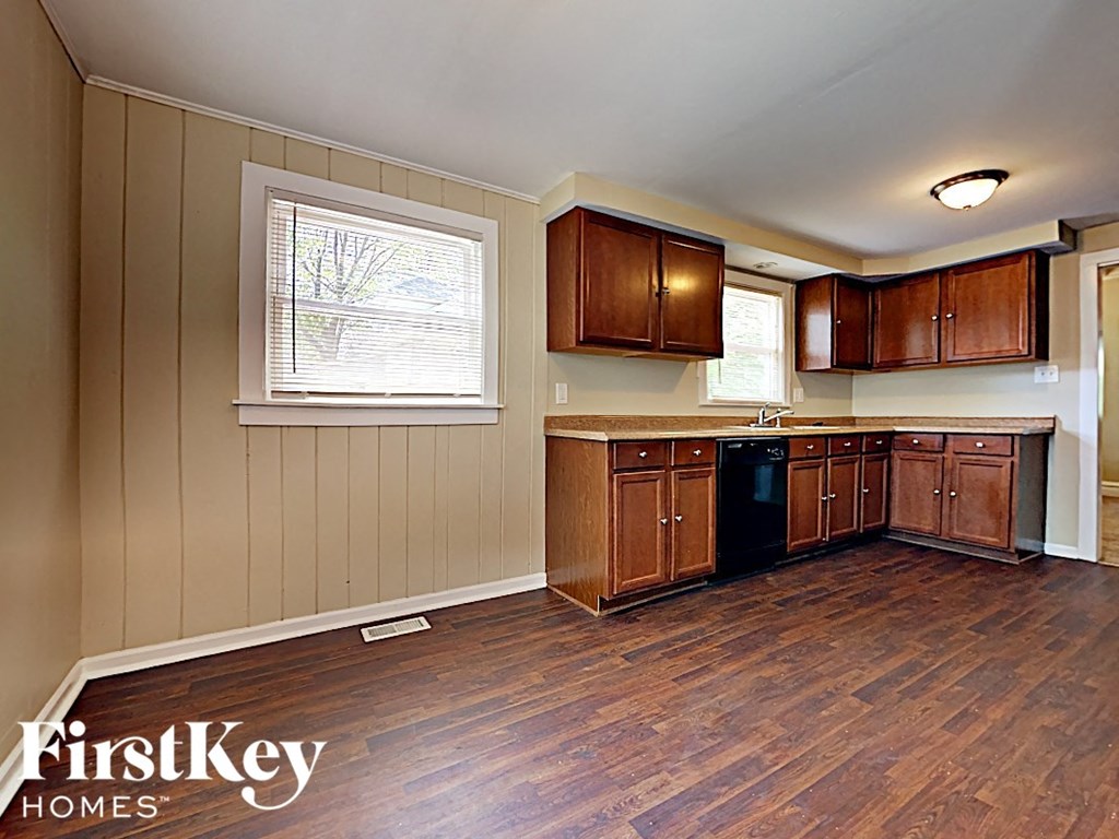 an empty kitchen with wood floors and wooden cabinets