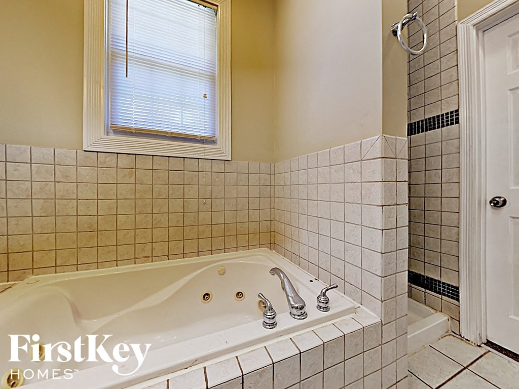 a jacuzzi tub in a white tiled bathroom