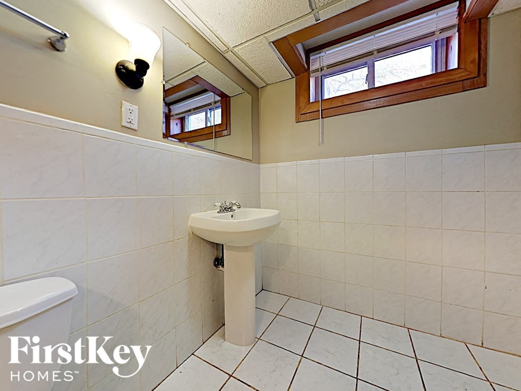 a bathroom with a sink and a mirror and a window
