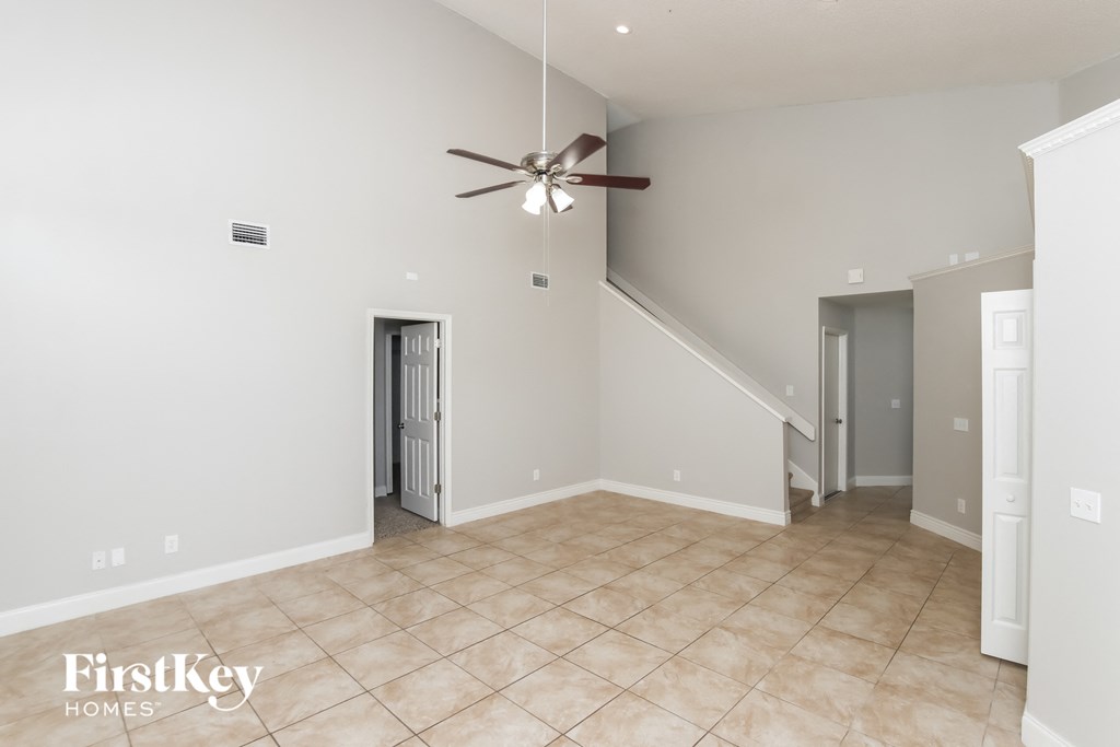 a living room with a ceiling fan and a tiled floor