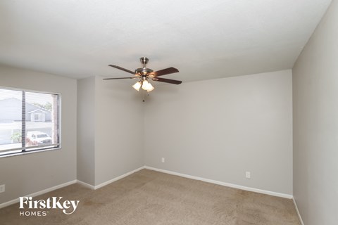 a bedroom with a ceiling fan and a window