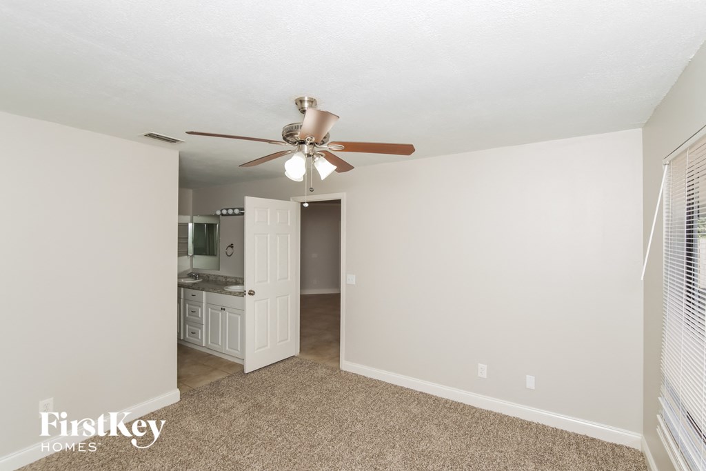 a living room with a ceiling fan and a kitchen