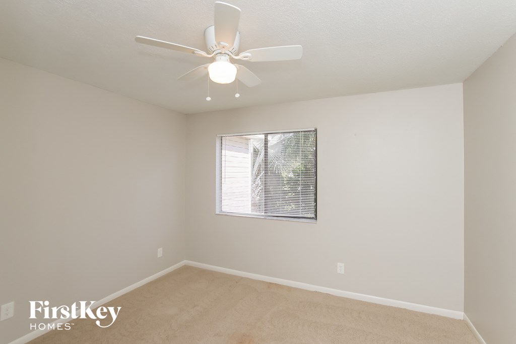 a bedroom with a ceiling fan and a window