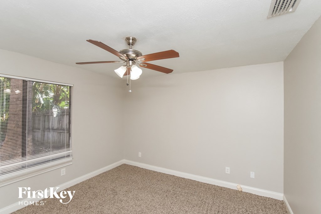the living room has a ceiling fan and a large window