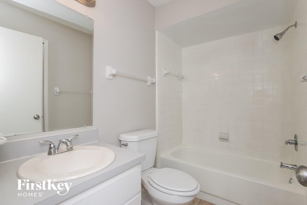 a white bathroom with a sink toilet and shower