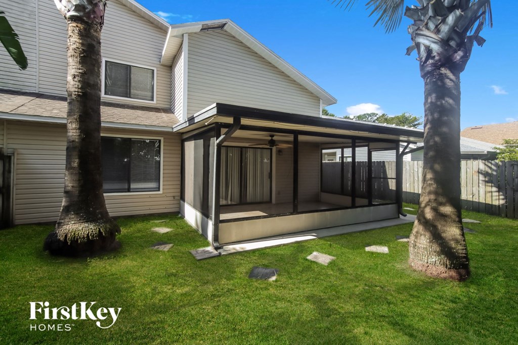 a screened porch in the backyard of a house