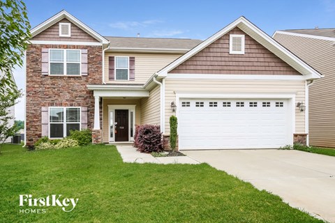 a house with a white garage door in front of a lawn