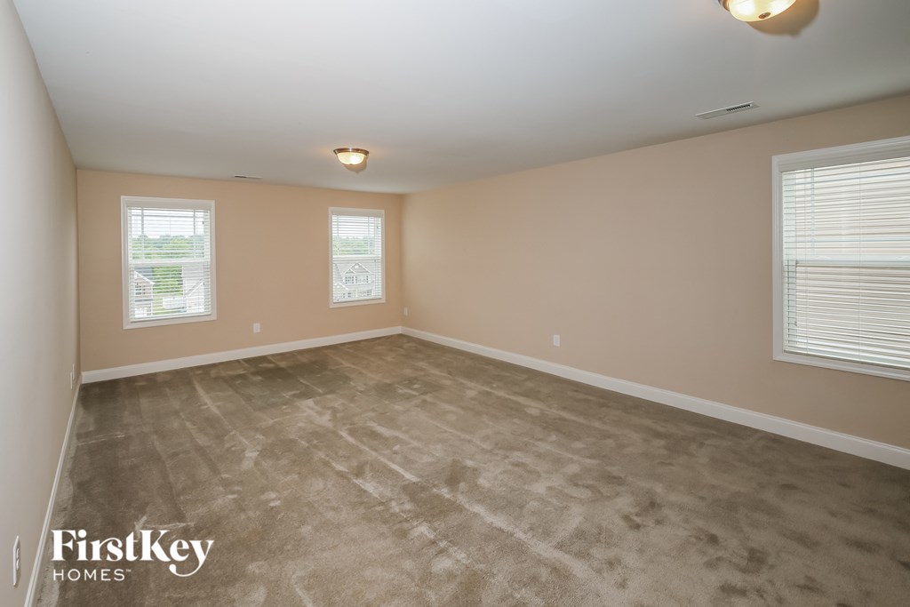 a bedroom with a carpeted floor and two windows