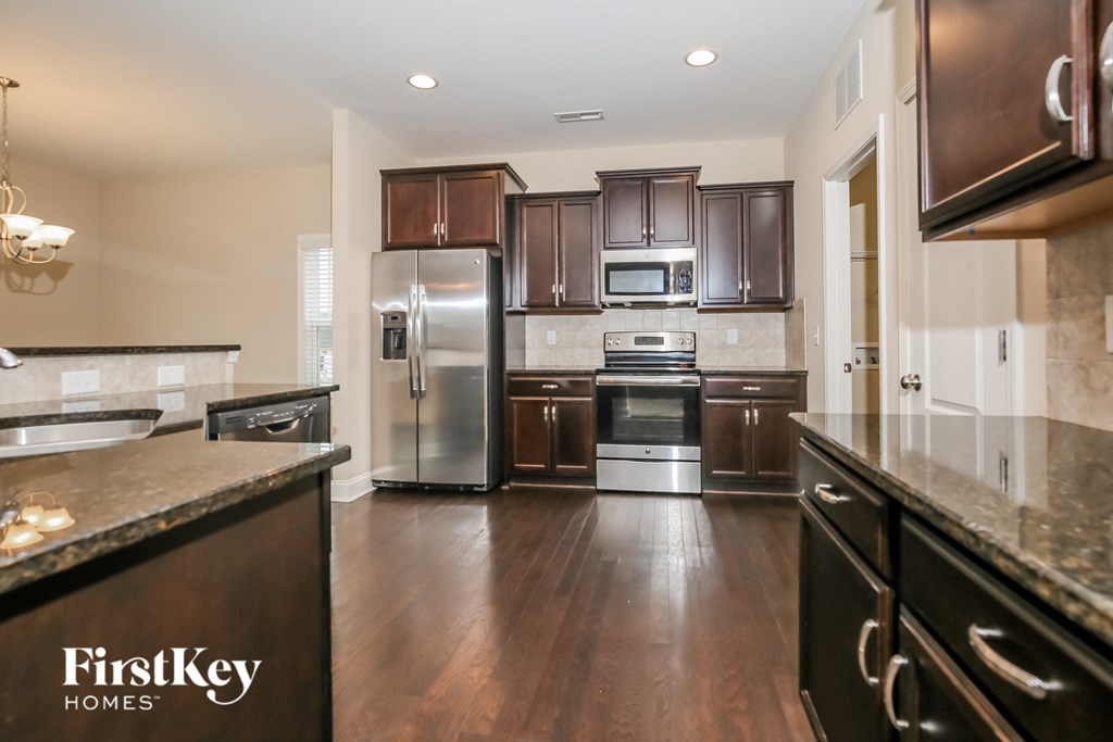 a large kitchen with stainless steel appliances and granite counter tops