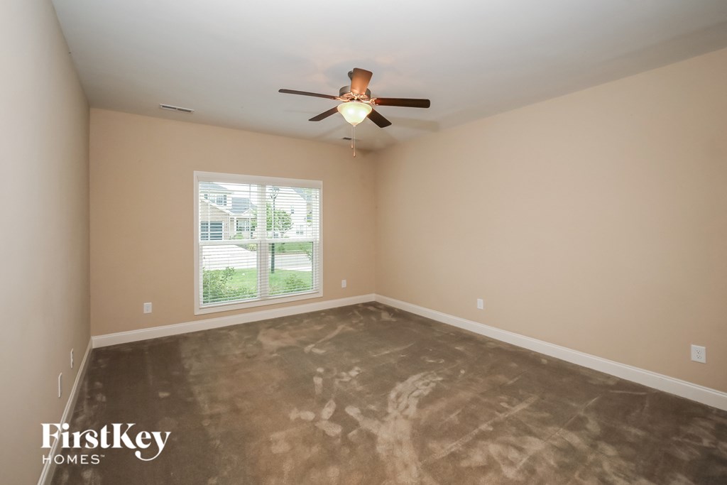 a bedroom with a ceiling fan and a window