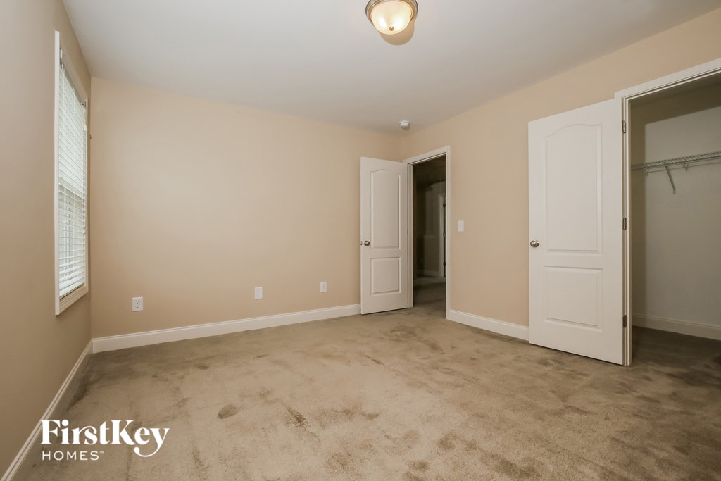 a empty living room with a closet and a door to a hallway