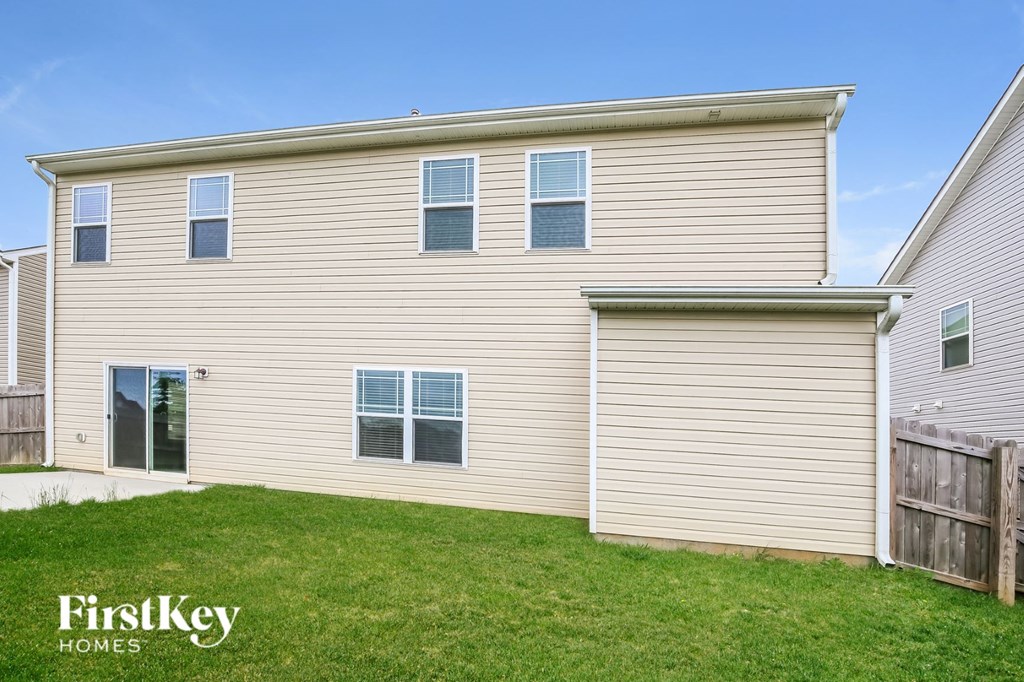 side view of a house with tan siding and green grass