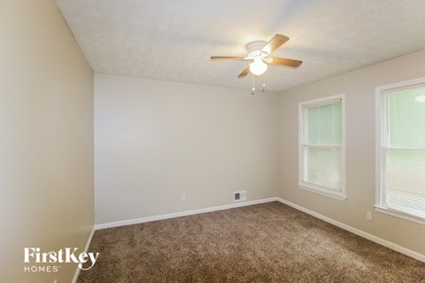 a bedroom with carpet and a ceiling fan