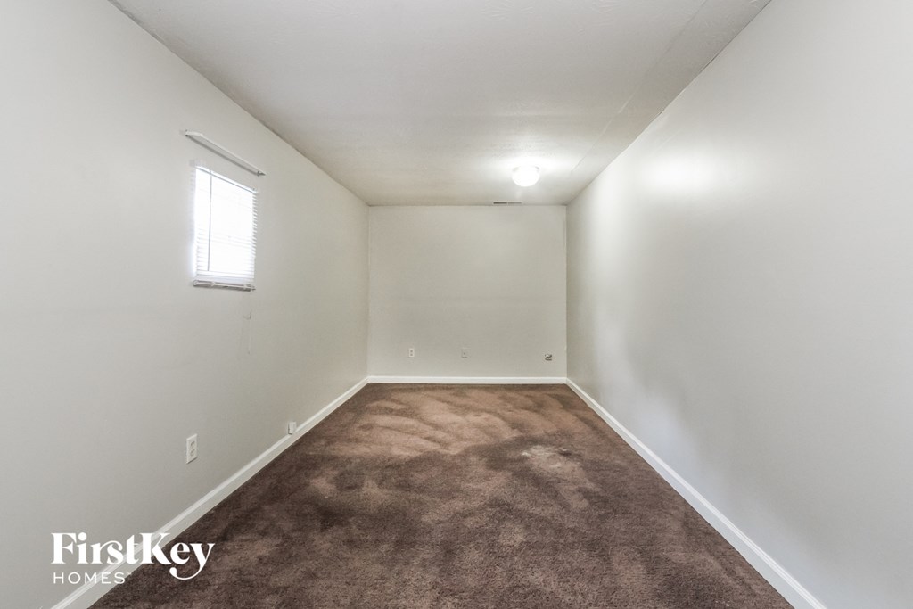 A room with a carpeted floor and a window.