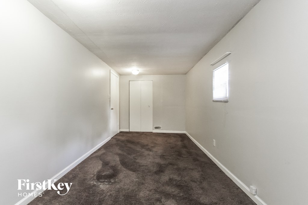 A long, narrow hallway with a carpeted floor and white walls.