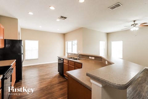 a kitchen with an island and a black refrigerator