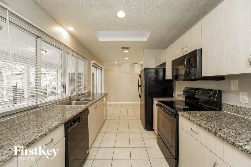 a kitchen with granite counter tops and black appliances