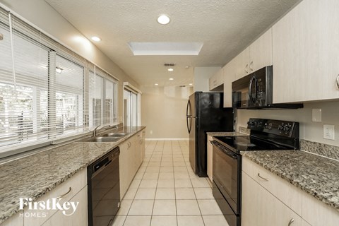 a kitchen with granite counter tops and black appliances