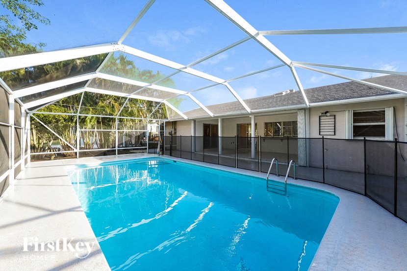 a swimming pool in a house with a patio and a pool enclosure