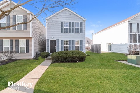 a white house with a lawn and a sidewalk