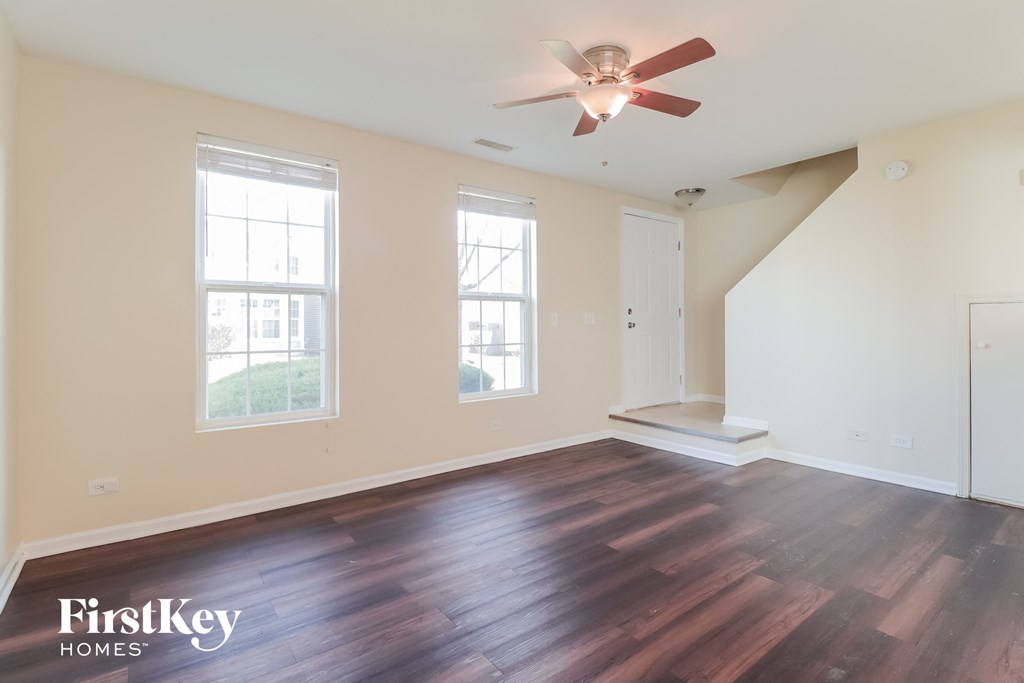 a living room with wood floors and a ceiling fan