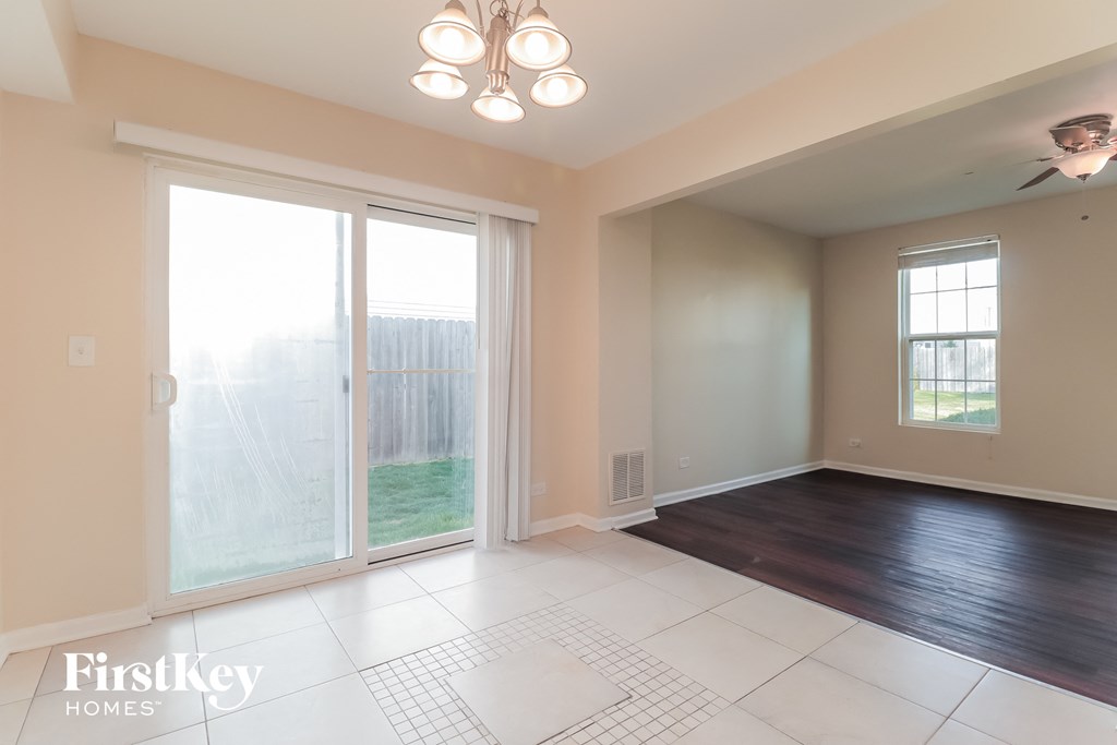 an empty living room with sliding glass doors to the backyard