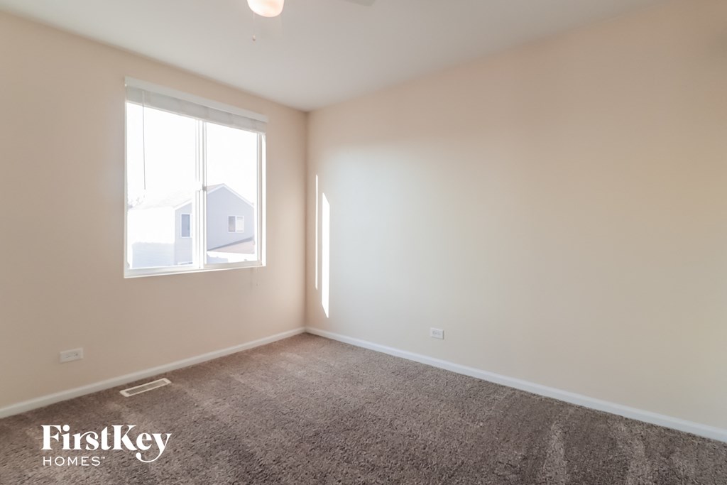 a living room with a large window and a carpet
