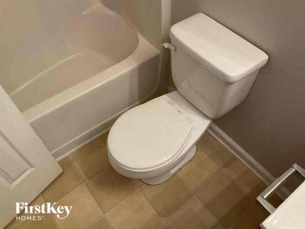 a bathroom with a toilet and a bath tub