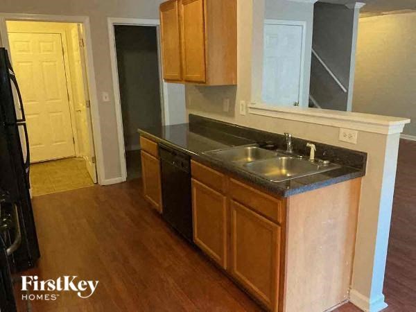 a kitchen with a sink and cabinets and a door