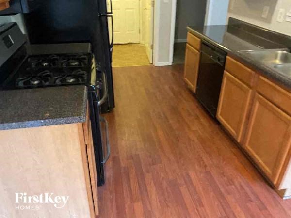 a kitchen with wood flooring and a stove and sink