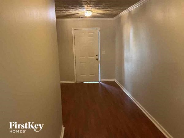 a small room with a white door and a wooden floor