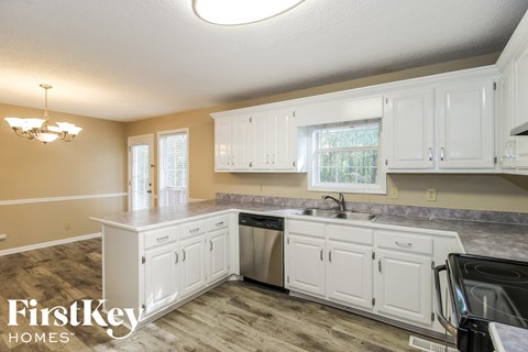 a kitchen with white cabinets and a sink and a counter top