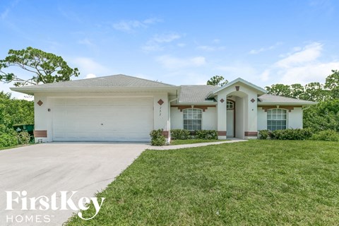 a white house with a lawn and a garage door