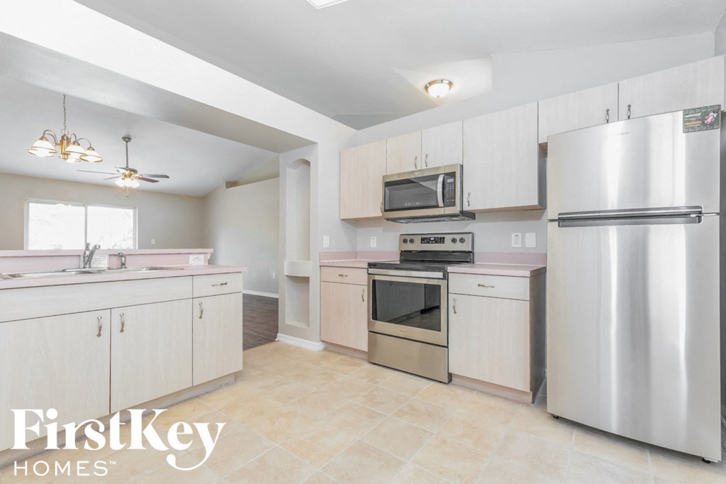 a kitchen with white cabinets and stainless steel appliances